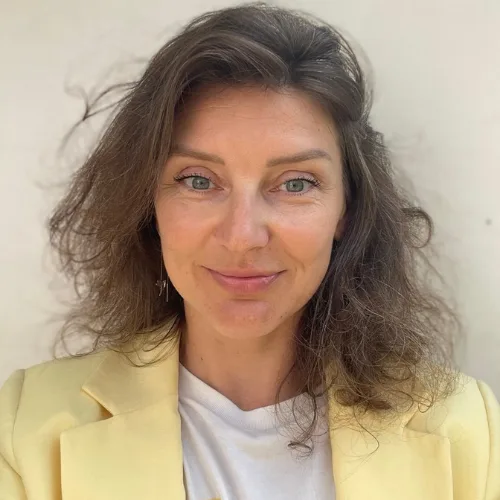 Olga Trubacheva smiling, wearing a soft yellow jacket